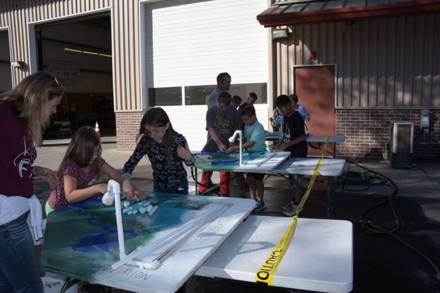 students learning from a 3D model outdoors